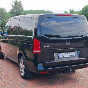 Juodas Mercedes-Benz V-Klasės automobilis pastatytas trinkelėmis grįstame kieme